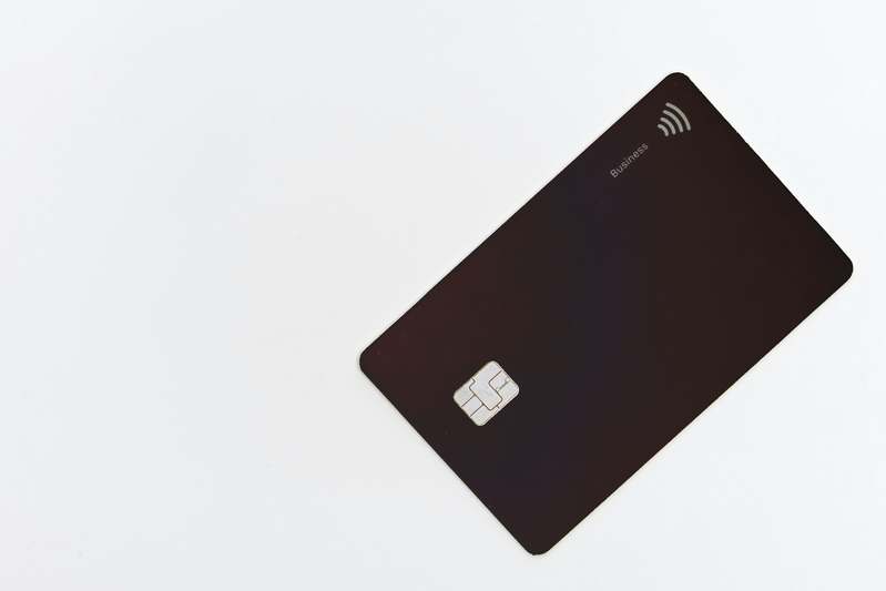 Top-down flat lay of premium metal credit cards including Chase Sapphire Reserve, American Express Centurion, and Capital One Venture X on brushed steel surface